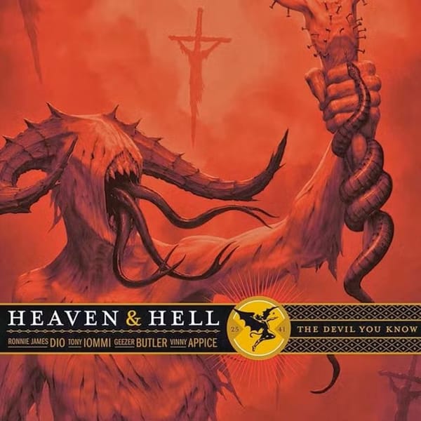 A demon figure holds a be-headed crucifix.